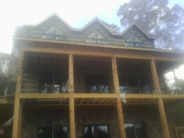 Dormers and porch framing on a large log home under construction — Roof Coating work by our crew in Herndon